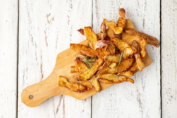 Potato peel chips with rosemary and salt on a white wooden table. Sustainable food. Top view.