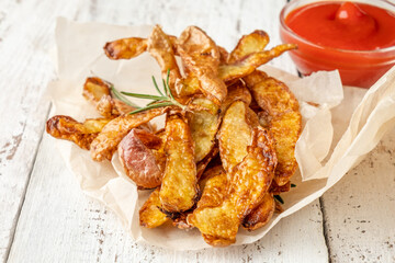 Homemade potato rind chips with spices on a white wooden table. Close-up. Sustainable food.