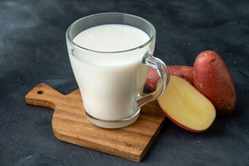 Milk from potatoes is a vegan product of a new generation. Dark table with potato tubers.