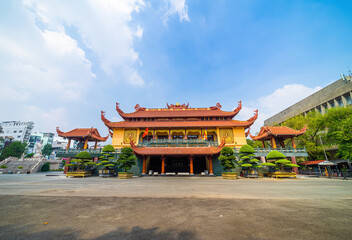Fototapeta premium Quoc Tu Pagoda in Vietnam, Ho Chi Minh.Red tall asian temple on the blue sky background in Saigon. It is a famous pagoda in Ho Chi Minh city. Travel and religion concept.