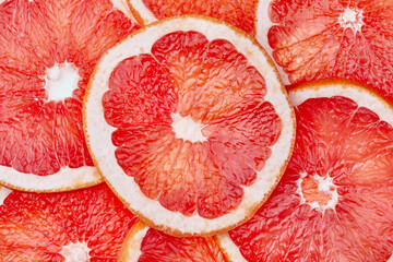 Abstract red background with citrus-fruit of grapefruit slices. Close-up. Studio photography.