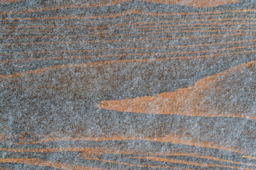 The dark wood floor is covered with a thin layer of snowflakes. The texture of the wood is visible through the snow. Background.