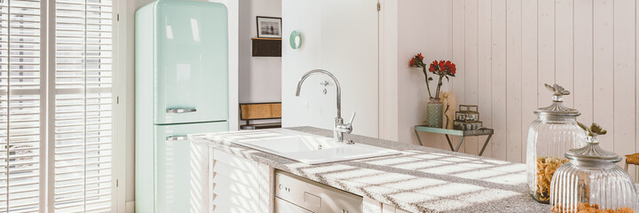 Bright kitchen interior with modern white furniture, pastel mint