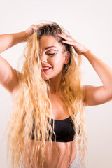 Obraz premium Portrait of a Caucasian blonde girl with makeup, groomed eyelashes and with a white background, vertical photo