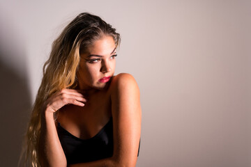 Fototapeta premium Portrait of a Caucasian blonde girl with eye drawing makeup, groomed eyelashes on a white background with a set of studio shadows