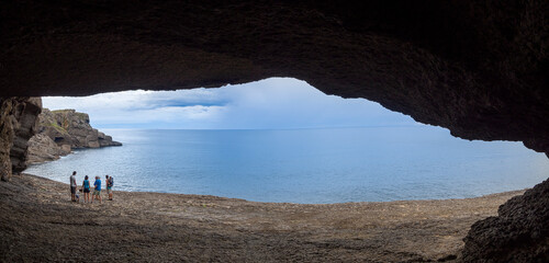 Vistas del paisaje de la Cueva de la Ojerada a contraluz, con siluetas y el mar azul en Cantabria, España, verano de 2020 © acaballero67
