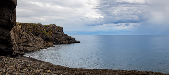 Vista del paisaje marítimo nuboso desde la Cueva natural de la Ojerada con paredes rugosas y...