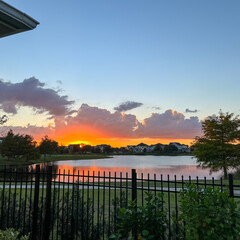 beautiful pink, orange and blue sunset reflecting on a lake in a suburban neighborhood.