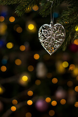 Heart toy figurine on Christmas tree. Holiday background.