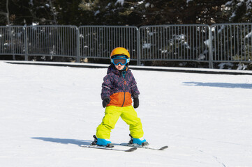 Fototapeta na wymiar Toddler Boy Dressed Warmly & in Good Safety Gear Ready to go Ski