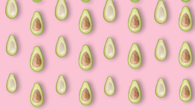 Colorful fruit pattern of fresh avocados on pink background with shadows. Seamless pattern with avocado. Realistic animation. 4K video motion