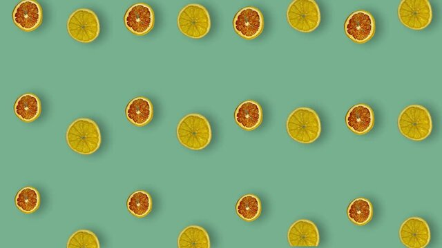 Colorful pattern of dried grapefruits and oranges slices on green background with shadows. Seamless pattern with dried grapefruit and orange chips. Pop art design. Realistic animation. 4K video motion
