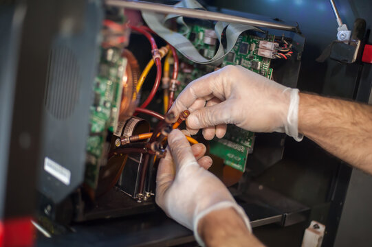Closeup view of electrical engineer operator repairs industrial printer plotter