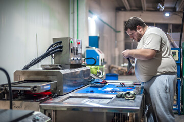Machinist technician operating with automatic heater stove heating PVC machine