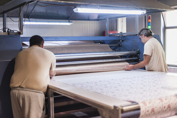 Technician works on large industrial textile sublimation heat printing machine