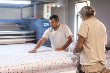 Technician works on large industrial textile sublimation heat printing machine