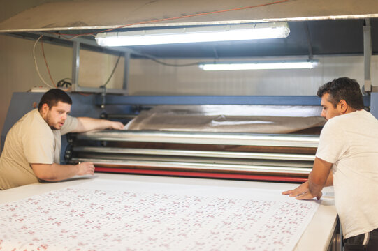 Technician works on large industrial textile sublimation heat printing machine