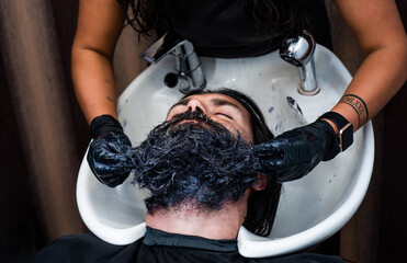 head of a guy in bathroom sink in hairdresser salon, barbershop