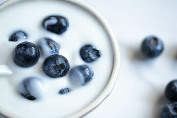 fresh blueberry yogurt in white cup on marble background