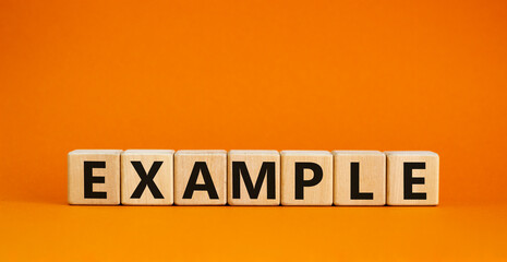Example symbol. The concept word Example on wooden cubes. Beautiful orange table, orange background, copy space. Business and example concept.
