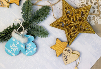 Fototapeta na wymiar Christmas decorations in the form of stars, hearts, blue mittens, a spruce branch on a light gray background, Christmas