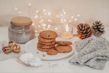 Christmas decorations with cookies and fir cones on the white table.