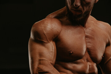 A close-up shot of a part of a torso of a bodybuilder during a workout.