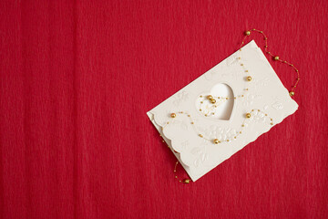 Creative layout with invitation card on red background. Flat lay. Minimal love concept.