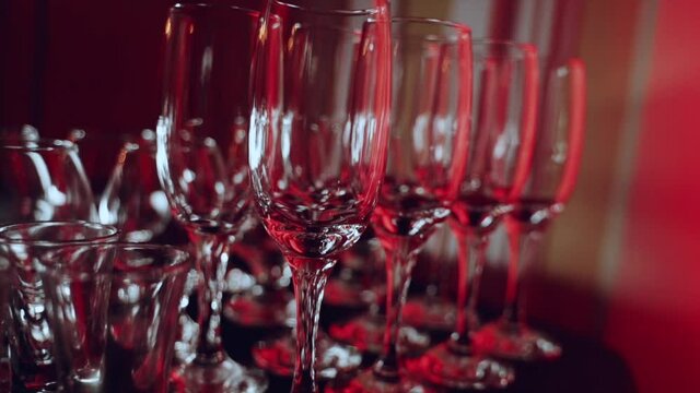Empty champagne glasses in the red color filling of the room