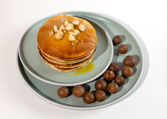 Stack of macadamia pancakes sprinkled with chopped nuts. Traditional Hawaiian dessert.