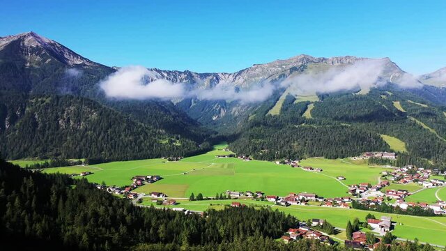 aerial panoramic video of Achenkirch in Achen valley (Achental) during sunny summer day with the mountain range of Karwendel (Tirol) in the background
