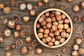 Bowl of hazelnuts on rustic wooden background; nuts for healthy diet snack; vegan food background, selective focus