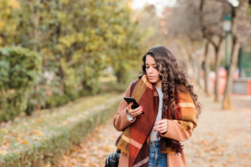 Spanish business woman communicating with smartphone in Castilla la mancha, Toledo. Fall colors
