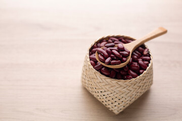 Organic red kidney bean in basket on wood table and wooden spoon. Protein nutrition ingredient for vegetarian.