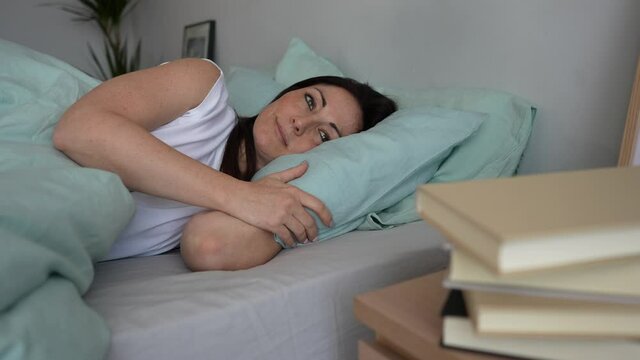 Pretty woman waking up in her bed after a healthy sleep.Concept good morning rest, relaxation, healthy life.