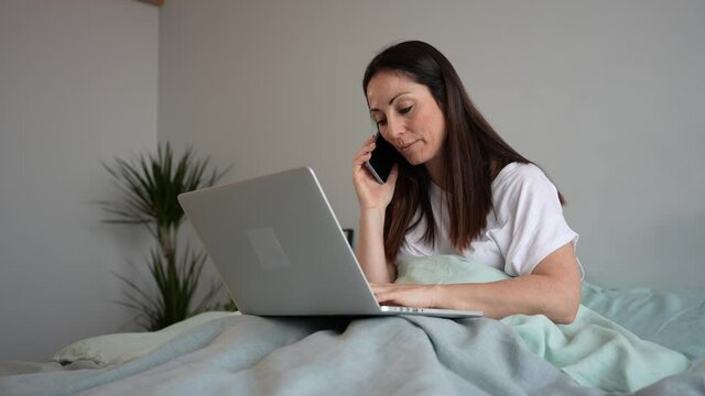 Woman talks on the phone and uses laptop to communicate with client to work from home.Concept work and study remotely, from home