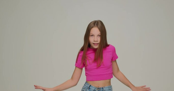 Stylish little child girl dancing having fun, cool moving. Energetic schoolgirl performing, showing modern dance