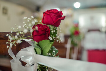 Rosas adornando un banco de iglesia 