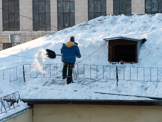 Hard work to remove snow from the roof of a building