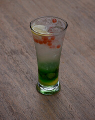 a glass of mojito on a wooden table