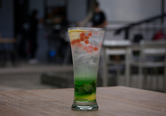 a glass of mojito on a wooden table