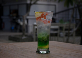 a glass of mojito on a wooden table