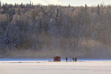 Ice fishermen gather on a foggy winter morning on Alaska's Otter Lake.
