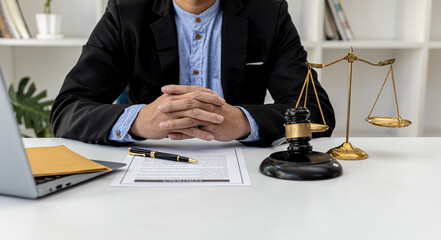 A male lawyer sits in his office, on a table with a small hammer to beat the judge's desk in court....