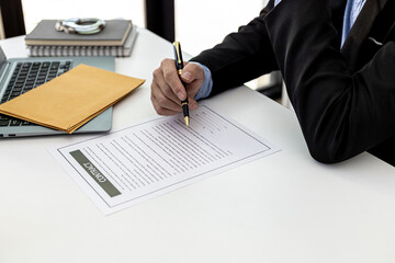 Lawyer reads the contract between the client and the parties, he has drawn up a contract to defend the client in a fraud case from a business partner. Concept of hiring a lawyer for legal proceedings.