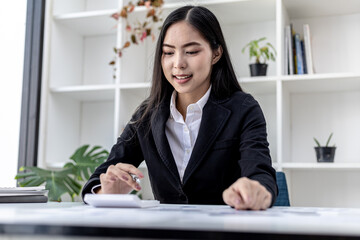 A business finance woman is reviewing a company's financial documents prepared by the Finance Department for a meeting with business partners. Concept of validating the accuracy of financial numbers.