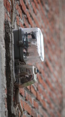 An electricity meter mounted on the wall of the house