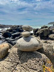 Fototapeta na wymiar Calming stacked rocks on a beach at Cathedral Rocks, Kiama, New South Wales, Australia
