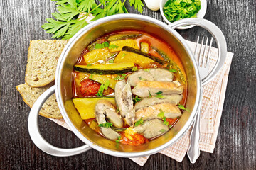 Chicken with stewed zucchini in saucepan on board top