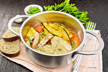 Chicken with stewed zucchini in saucepan on board
